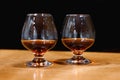 Two goblets of brandy on wooden old counter top Royalty Free Stock Photo