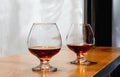 Two goblets of brandy on wooden old counter top Royalty Free Stock Photo
