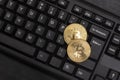 Two gold Bitcoins on computer keyboard close up. Electronic virtual money. Mining cryptocurrency concept Royalty Free Stock Photo