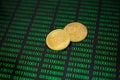 Two gold coins bitcoin on the background of green zeros and ones of the program code Royalty Free Stock Photo