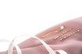 Two gold-colored hairpins decorated with pearls on the powder pink silk folded fabric with light-pink ribbon background. Use for b Royalty Free Stock Photo