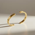 Two gold cuff bracelets, positioned upright on a reflective surface. The bracelets are Royalty Free Stock Photo