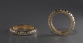 Two gold rings with diamonds surrounding the ring on a studio background in 3D desing. Royalty Free Stock Photo