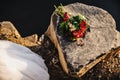 Two gold rings lying on a big gray stone. Red wedding bouquet. White dress bride. Nature. Basalt rock. Rock. Near the lake Royalty Free Stock Photo