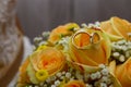 Two gold rings placed on a bouquet of yellow roses. Wedding ornament.