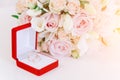 Two gold rings in red box near beautiful creame roses on white background Royalty Free Stock Photo