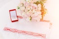 Two gold rings in red box near beautiful creame roses on white background Royalty Free Stock Photo