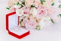 Two gold rings in red box near beautiful creame roses on white background Royalty Free Stock Photo