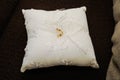 Two gold rings on a small white cloth cushion