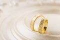 Two gold wedding rings on beige background Royalty Free Stock Photo
