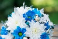 Wedding rings on a bouquet of blue and white flowers.