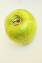 Two gold wedding rings with a diamond on the green apple on a white background Royalty Free Stock Photo