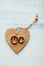 Two gold wedding rings with  lettering `Love` engraved on wooden heart shaped stand. Wedding and love concept. Selective focus. Royalty Free Stock Photo
