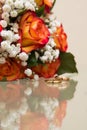 Two gold wedding rings lie on a bouquet.