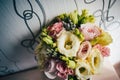 Two gold wedding rings lying on bouquet. beautiful tender wedding bouquet of cream roses, eustoma flowers. Decorations brown Royalty Free Stock Photo