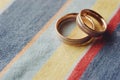 Two gold wedding rings lying on colored cloth Royalty Free Stock Photo