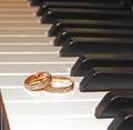 Two gold wedding rings on piano Royalty Free Stock Photo