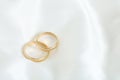 Two gold wedding rings on a white satin. Royalty Free Stock Photo