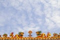 Two Golden artistic grand yellow Asian dragons statue on the roof of a temple