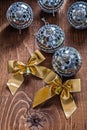 Two golden bows and christmas disco mirror balls on old wooden b Royalty Free Stock Photo