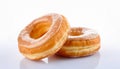 Two golden-brown glazed donuts, with a glossy sheen, are set against a white background
