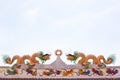 Two golden Chinese stucco art on the roof of a Chinese temple on the sky background Royalty Free Stock Photo