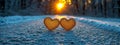 Two golden hearts shine against a snowy backdrop with a rising sun