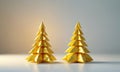 Two golden origami Christmas trees stand on white surface, casting shadow on the ground, with soft light Royalty Free Stock Photo