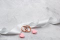 Two golden rings and white satin ribbon wedding decor Royalty Free Stock Photo