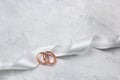 Two golden rings and white satin ribbon Royalty Free Stock Photo