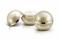 Two golden sphere cosmetic jar on white