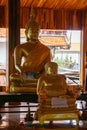 Two golden statues, including statue of Buddha, are at the Thai Buddhist temple Royalty Free Stock Photo