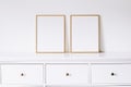 Two golden vertical frames on white furniture, luxury home decor and design for mockup creation