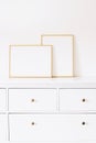 Two golden vertical and horizontal frames on white furniture, luxury home decor and design for mockup creation
