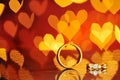 Two golden wedding rings with heart bokeh on background.Concept Royalty Free Stock Photo