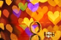 Two golden wedding rings with heart bokeh on background.Concept Royalty Free Stock Photo