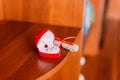 Two golden wedding rings in heart-shaped box with cute scroll stylized as musical notes at rustic wooden furniture backgr Royalty Free Stock Photo