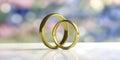 Two golden wedding rings isolated on white table, blur background, closeup view, 3d illustration Royalty Free Stock Photo