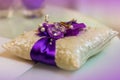 Two golden wedding rings on purple and white small pillow Royalty Free Stock Photo