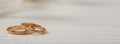 Two golden wedding rings on white wooden background, banner, copy space Royalty Free Stock Photo