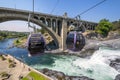 Two gondolas fly over the Spokane River and falls near Riverfront Park on a summer day in Spokane, Washington, USA