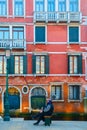 Two gondoliers are talking on the square in Venice on the background of facade of a beautiful ancient building