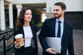 Two good looking office workers leaving working place