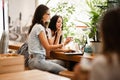 Two good looking young girls with long dark hair,wearing casual style,sit at the table and look attentively at the Royalty Free Stock Photo