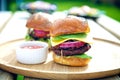 Two gourmet burgers with sauce on the side outdoors. Royalty Free Stock Photo