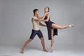 Two athletic modern ballet dancers are posing against a gray studio background. Royalty Free Stock Photo