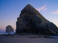 Two granite rocks, one large, on the shore in the foreground, the other smaller, in the ocean. Dusk. Sunset. The greatness of