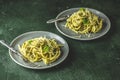 Two gray dishes of spaghetti pasta bucatini with pesto sauce and parmesan. Italian traditional perciatelli pasta by genovese pesto