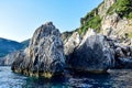 Two gray low cliffs sticking out of the water