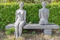 Sania, Hainan China - 12 12 2019: Two gray marble sculptures of young naked women on a garden bench in summer